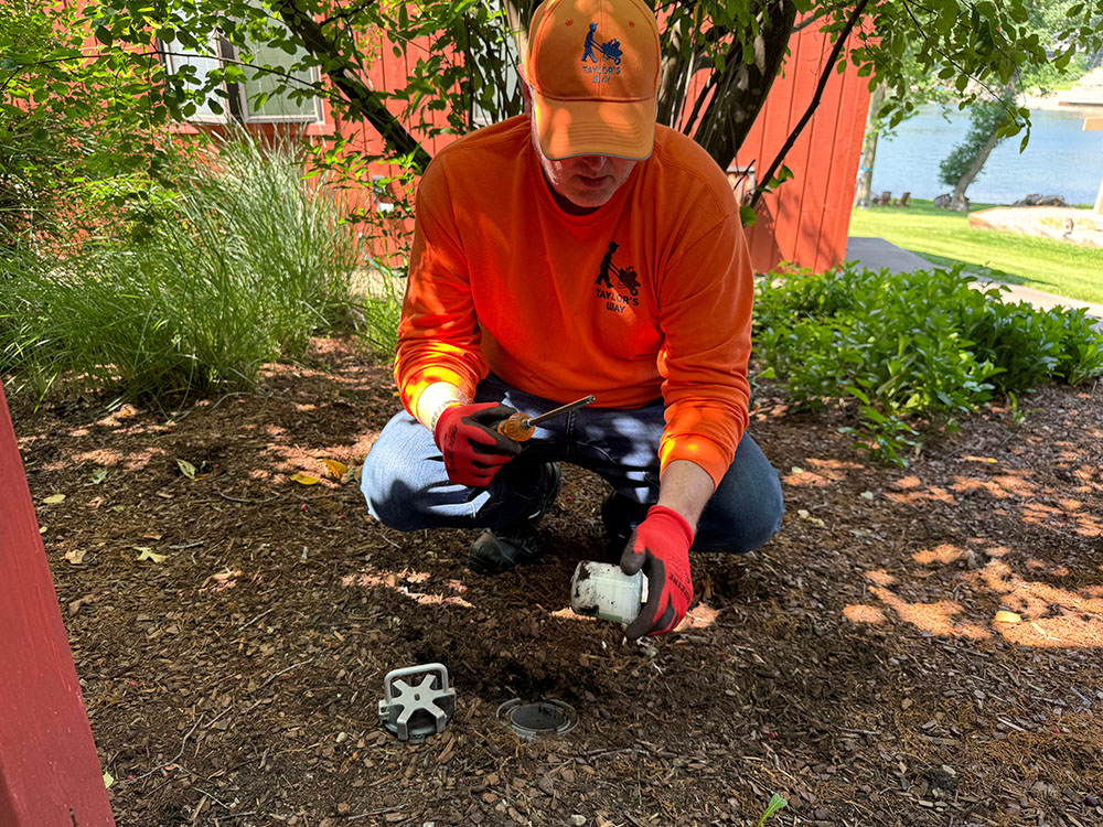 Technician installing a discreet termite bait station
