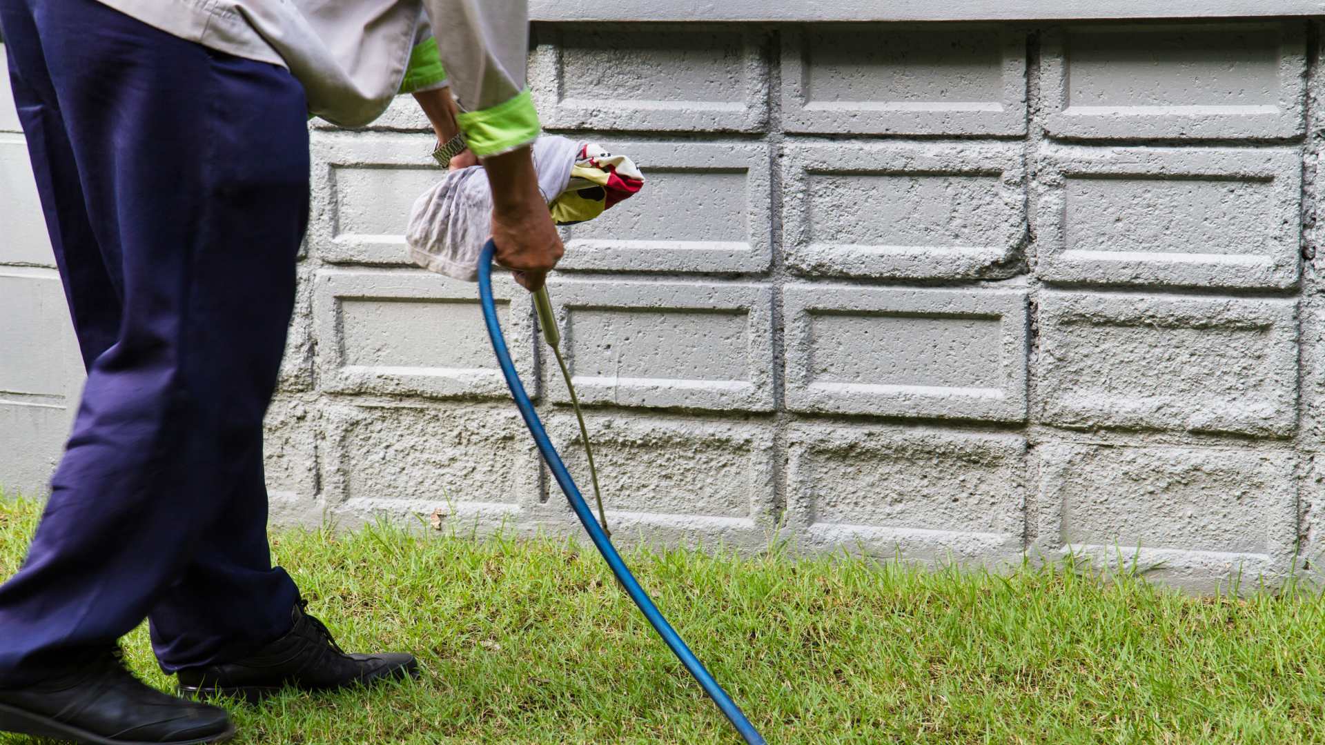 Perimeter pest control being applied along a home foundation by Elite Lawn Care