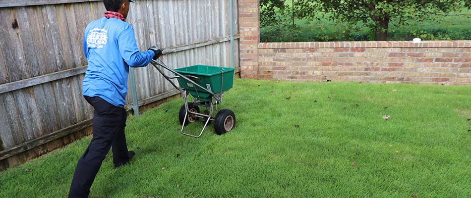 Elite Lawn Care worker fertilizing a lawn in Del City, OK