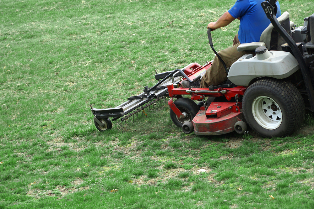 Zero-turn mower with a dethatching attachment on a Lansing lawn