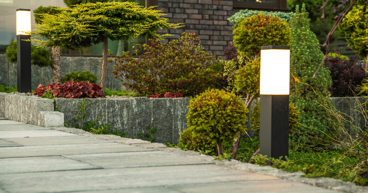 Low-voltage bollard path lights along a stone-edged walkway and garden bed