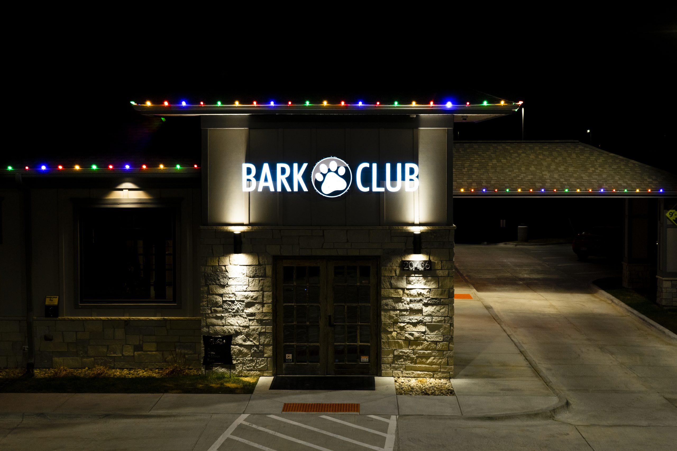Bark Club storefront at night with multicolor lights along the roofline