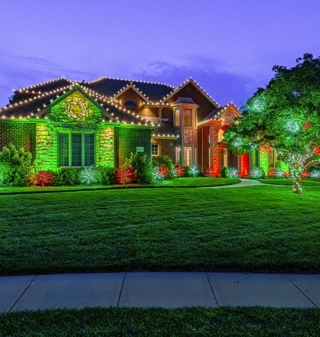 Warm white C9 roofline lights on a two-story brick home in Vestavia Hills, AL, installed by New Age Lights