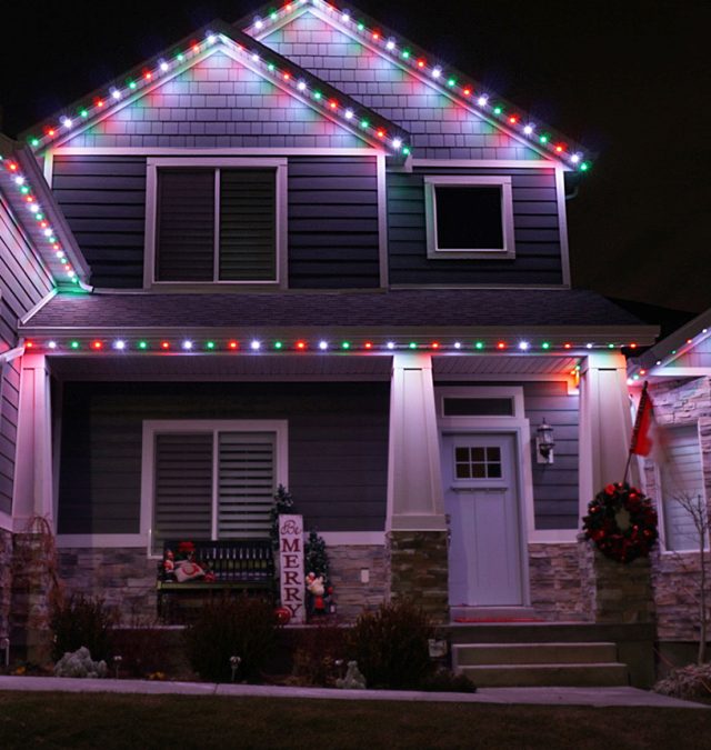 Installer fastening a color-matched aluminum lighting track to the painted wood fascia of a slate-roofed Hyde Park, Cincinnati home from a lift, no fasteners in the roofing