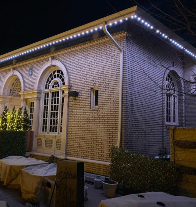 Daytime photo of a Mason, Ohio HOA home showing a color-matched permanent lighting track blending into the white aluminum fascia, nearly invisible from the sidewalk, installed by New Age Lights
