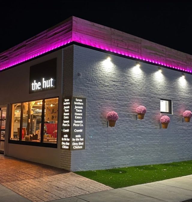 Bosso Smart Lighting track under the soffit of a two-story home in Alabama at dusk, running a warm true-white scene, with the color-matched channel invisible against the trim
