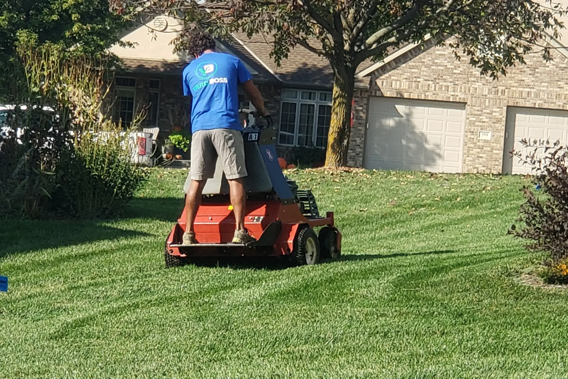 Yard Boss core aerator pulling soil plugs from a Lincoln, Nebraska lawn during fall aeration and overseeding service
