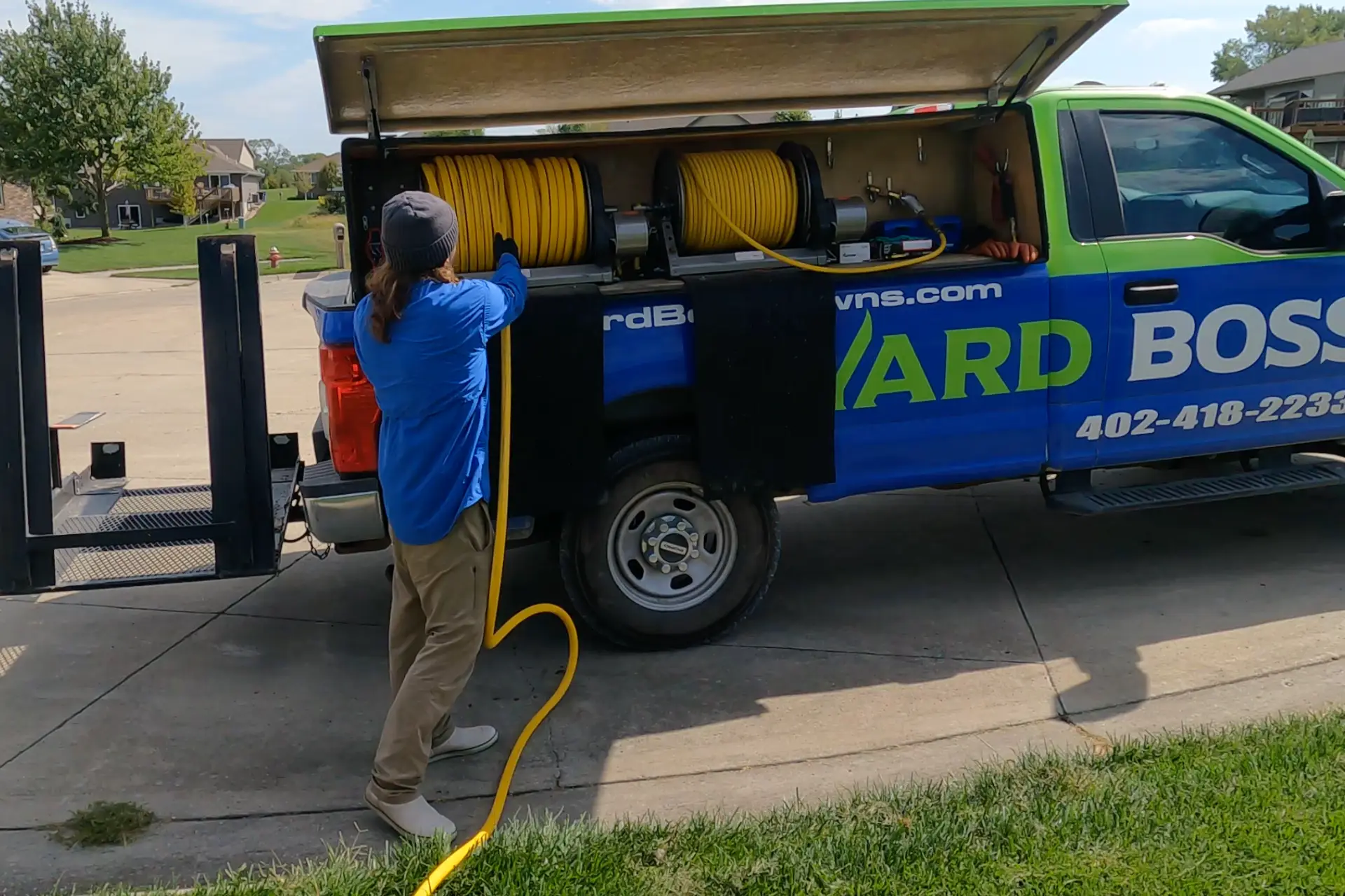 Yard Boss technician applying a balanced spring fertilizer treatment on a Lincoln NE lawn representing the rate-controlled May feeding that builds deep roots and summer-ready turf across Lancaster County