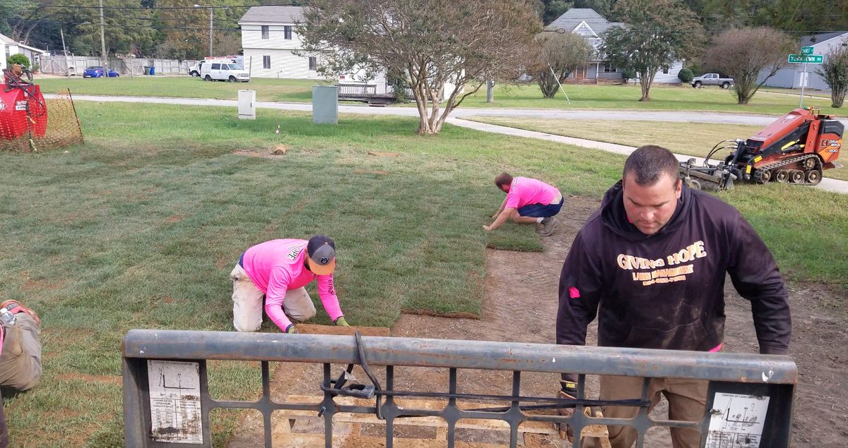 A Giving Hope Lawn Management crew laying fresh sod on a Central Virginia property