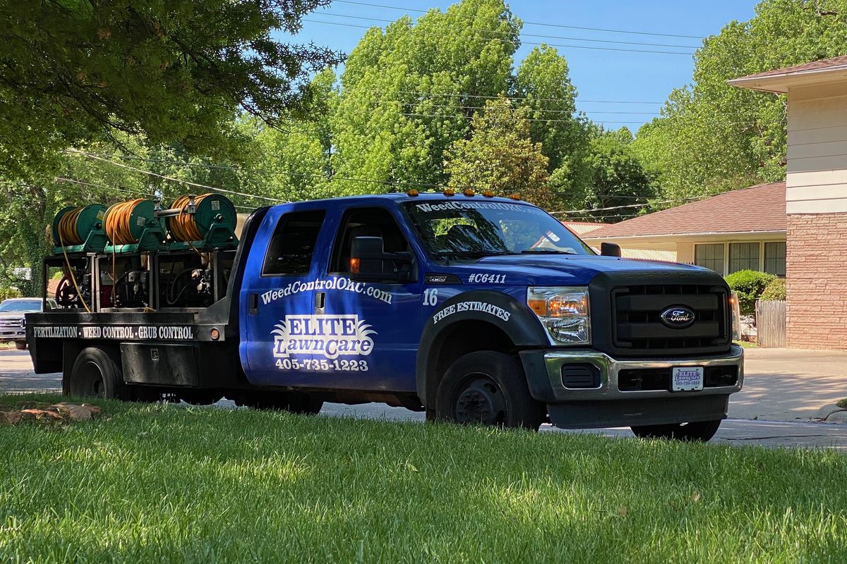 An Elite Lawn Care truck parked at a lawn for a fall weed control treatment