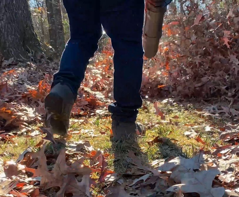 A person walking through a thick layer of fallen leaves in a Memphis yard in fall