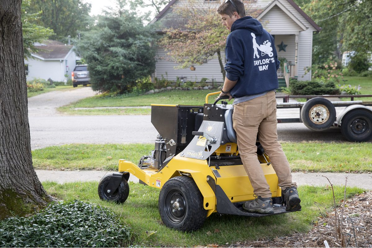 A Taylor's Way team member aerating a residential lawn ahead of fall seeding