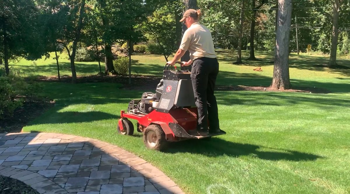 Ant's Plants technician core aerating a North Jersey lawn ahead of fall overseeding