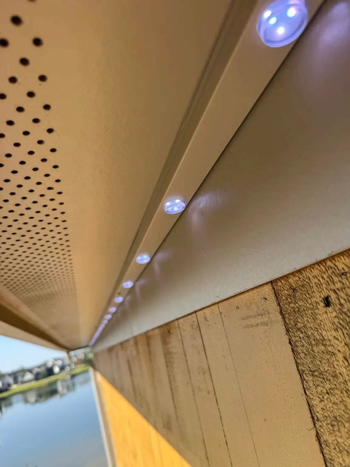 Close-up of permanent LED lights set in a color-matched track under a vented soffit in Vestavia Hills, AL