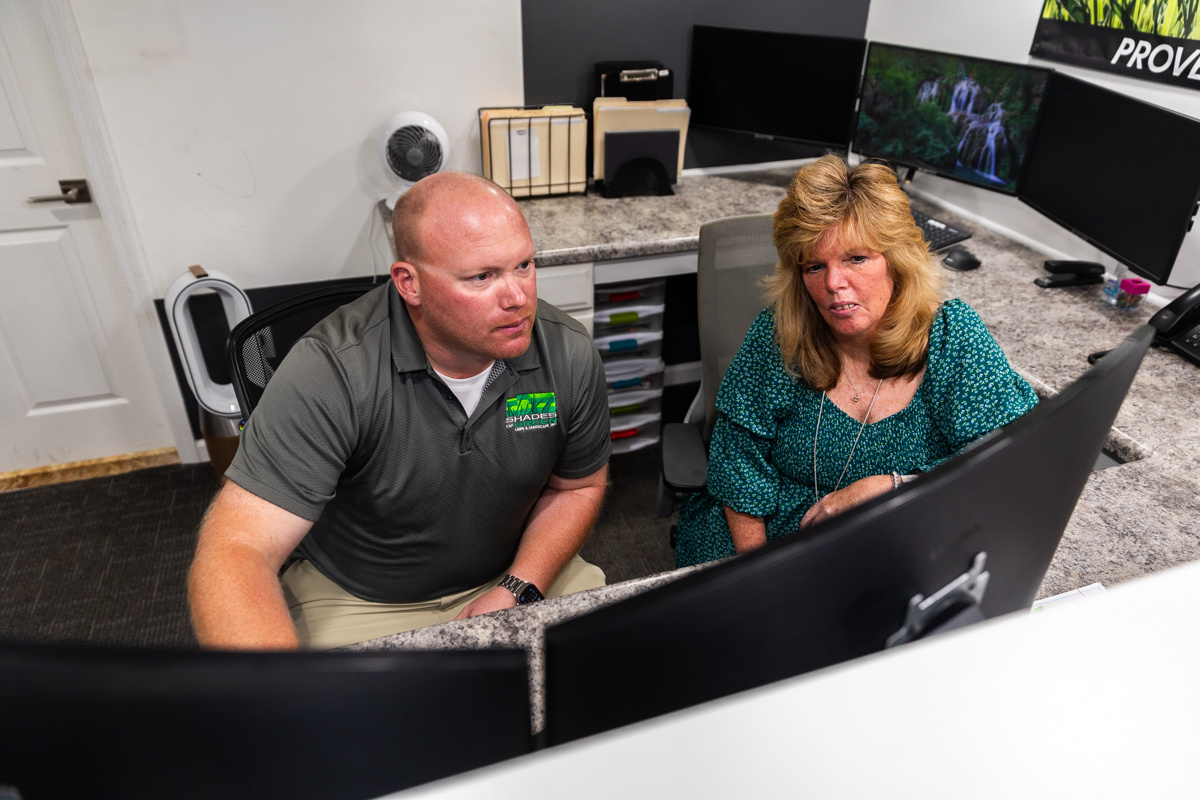 Two Shades of Green team members working together at an office computer