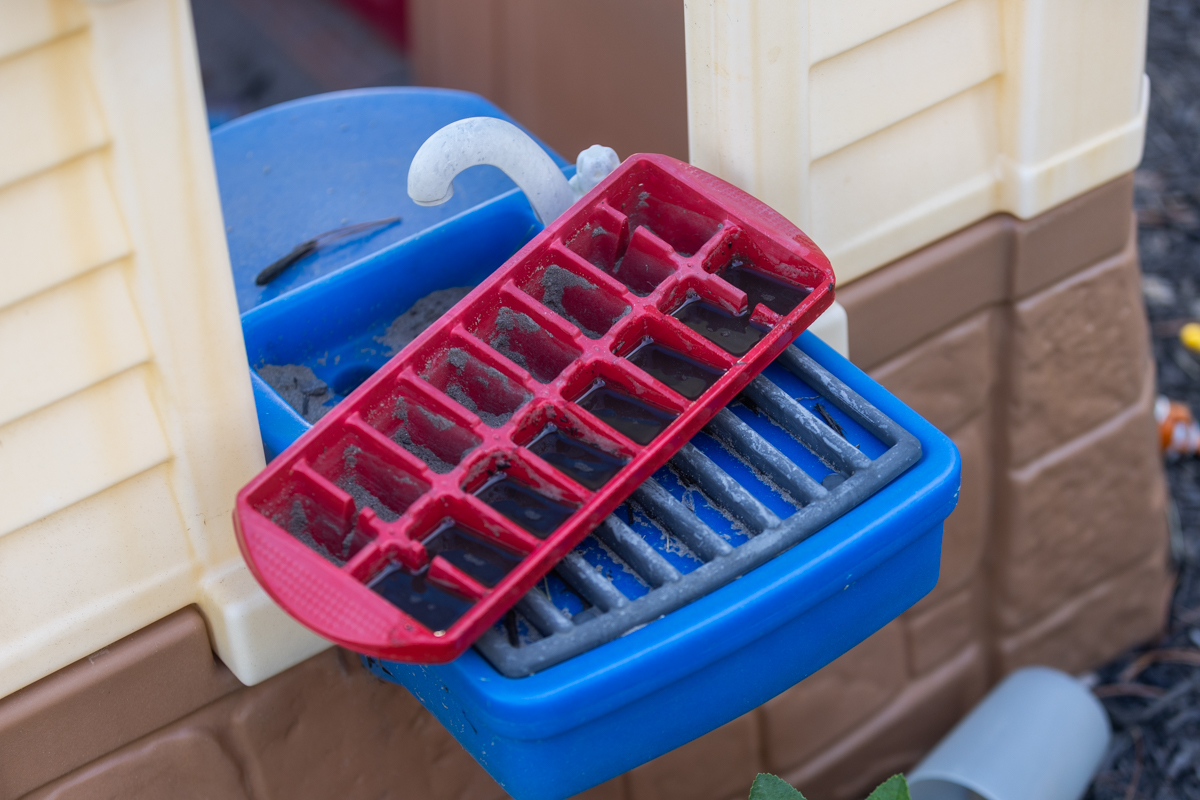Child's play-kitchen sink collecting standing water outdoors